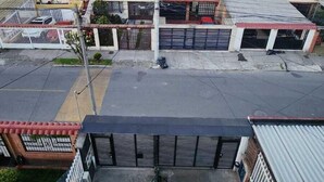 A multi-story residential building with a parking area in front. - Hotel Natural Sevgi (Bogotá)