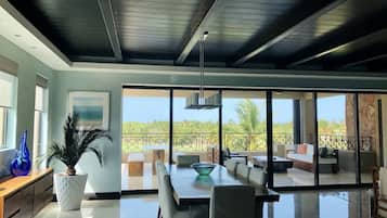 Un amplio salón con una gran mesa de comedor, asientos cómodos y vistas al exterior.