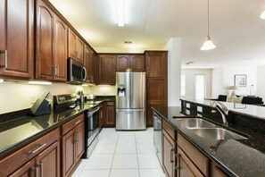 Enjoy cooking in this well-equipped kitchen with a granite countertop, stainless steel appliances, and a sink.