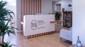 A reception desk with a modern design, featuring a logo and the name 'NIA Boutique Hotel by Rapos Resort'. - Nia Boutique Hotel by Rapos Resort (Himarë)