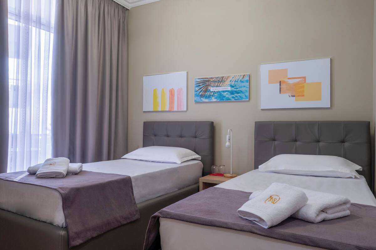 Ein Hotelzimmer mit zwei Betten, einem Nachttisch und einem Bild an der Wand.
