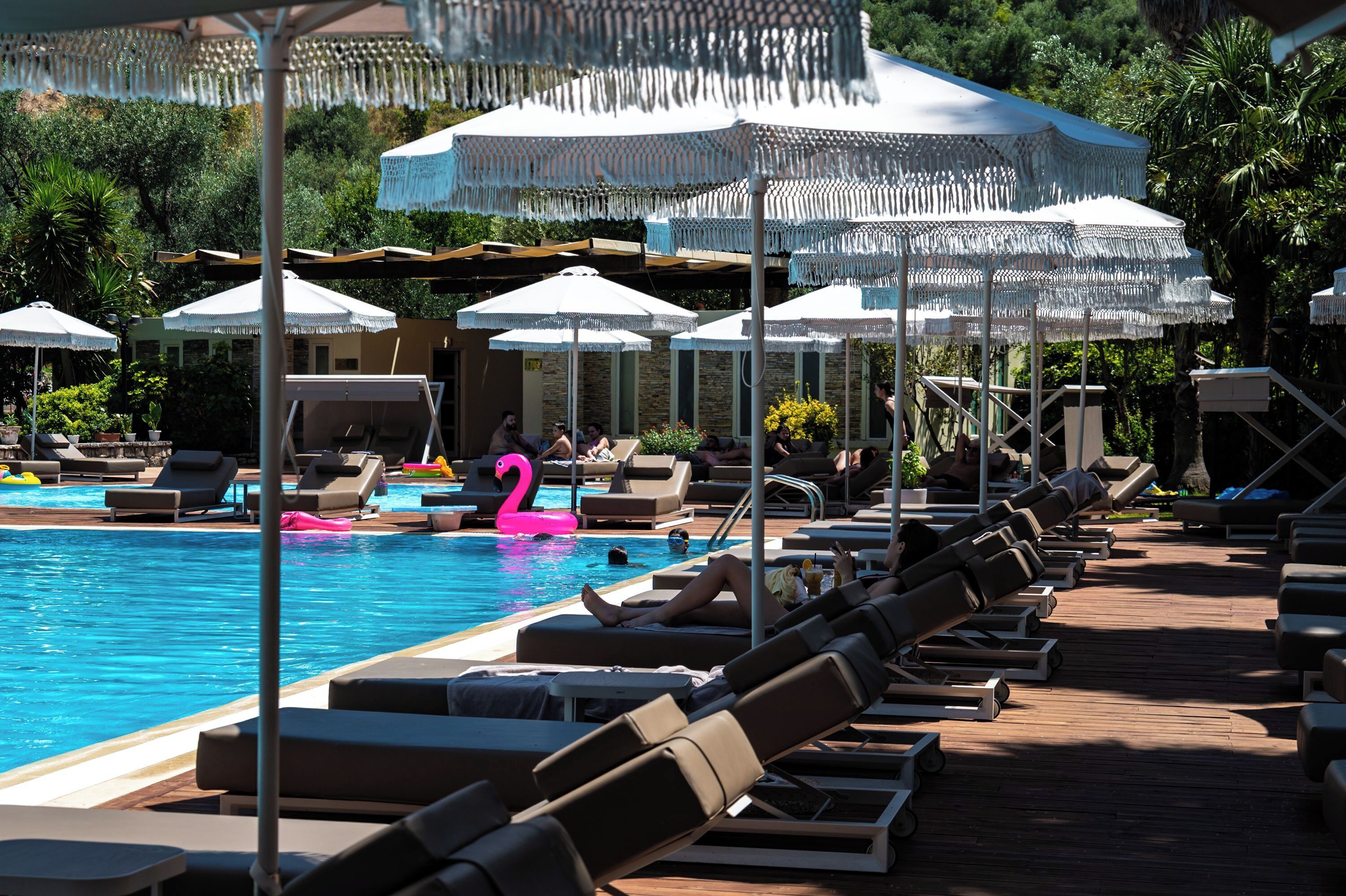 A poolside area with lounge chairs and umbrellas.