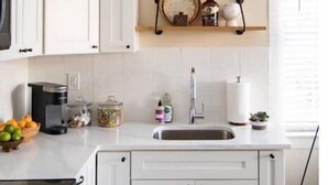 A modern kitchen with white cabinets, a built-in stove, a sink, and a countertop with various items. - The Downtown Hibiscus House (West Palm Beach)