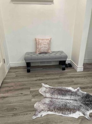 A cozy space for relaxation, featuring a tufted bench and plush rug.