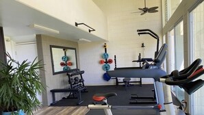A gym with cardio equipment, weight machines, and a treadmill. - Turtle Beachfront, snorkeling, free parking, wash-dryer in unit, New bigger AC.  (Hauula)