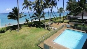 A pool with a view of the ocean and palm trees. - Turtle Beachfront, snorkeling, free parking, wash-dryer in unit, New bigger AC.  (Hauula)