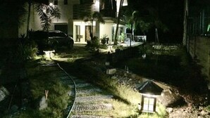 A modern house at night with a driveway leading to the entrance, surrounded by greenery and a small garden area. - Casa Herminia Second Floor Studio with Balcony (Baler)