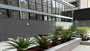 A modern building with large windows and a landscaped area with planters. - Beautiful Studio near Av Paulista and Sírio Libanês (Bela Vista São Paulo)