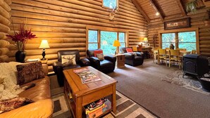 Ein rustikales Holzhaus-Interieur mit Kamin, Ledermöbeln und Essbereich.