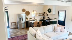 Una cocina moderna con refrigerador, estufa y comedor integrados.