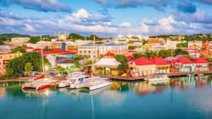 A coastal town with a marina, colorful buildings, and a clear sky.