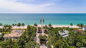 A beach resort with a pier extending into the ocean, surrounded by palm trees and beachfront properties. - Villa Bellevue - Beautiful lakefront rental with pool with 3 bedroom & 2 bath (Naples)