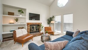 A living room with a fireplace, a sofa set, a coffee table, and a TV mounted on the wall. - Elm Grove Elegance (Boise)