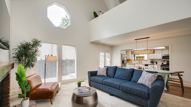A spacious living room with a large sofa, a coffee table, and a potted plant. - Elm Grove Elegance (Boise)