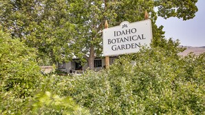 Letrero del Jardín Botánico de Idaho, rodeado de abundante vegetación.
