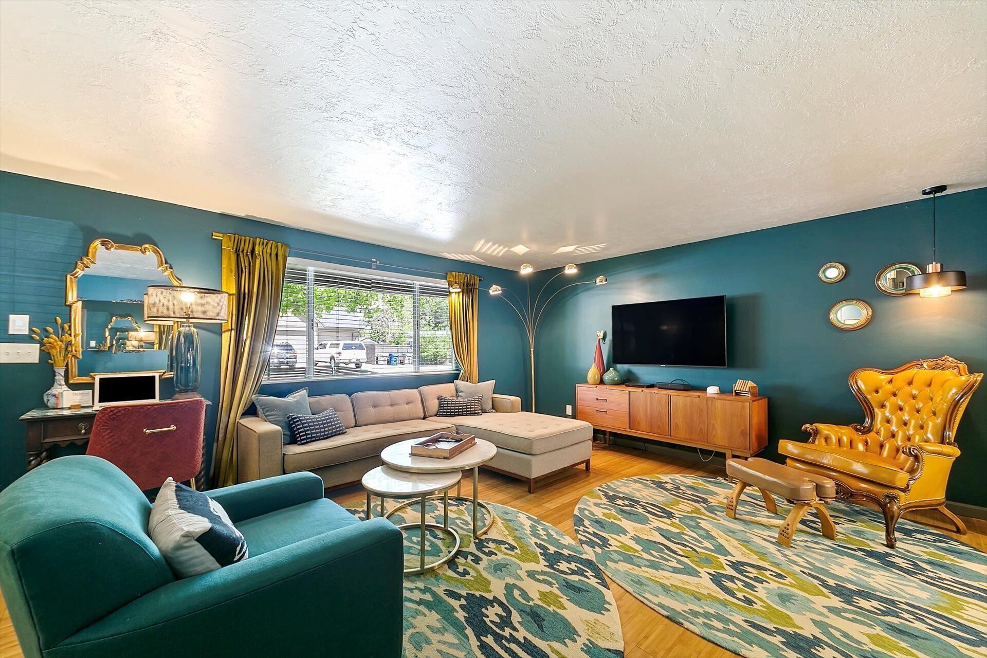 A modern living room with a sofa, armchair, and a television.