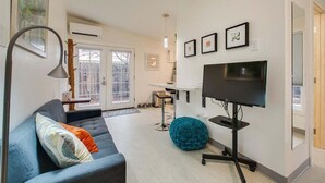 A modern living room with a sofa, a TV, and a bar area. - The Green Spot Studio (Boise)