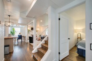 A spacious hallway with a staircase leading to a bedroom. - The Valiant Vic (Boise)
