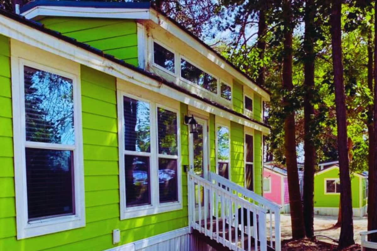 A bright green building with white trim and multiple windows.