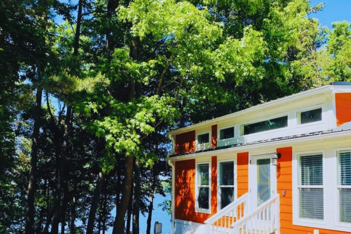 A two-story house with a white front porch and orange siding.