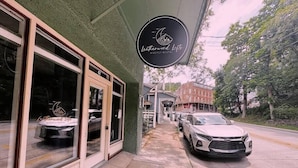 Rakennuksessa on kyltti, jossa lukee ”Leatherwood Lofts – vuokrattavissa myös yhdeksi yöksi”, ja sen edessä on pysäköity auto.