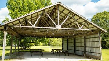 A covered picnic area with benches and a shelter structure.