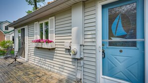 A house with a blue door, a window with pink flowers, and a porch with chairs. - 'Summer Place' A Vibrant Rental on Lake Huron (Tawas City)