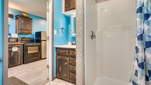 A bathroom with a shower, a sink, and a mirror.