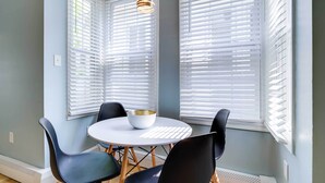 A dining area with a round table, four chairs, and a bowl on the table. - Charming Ocean City Apartment < 1 Mi to Boardwalk! (Ocean City)
