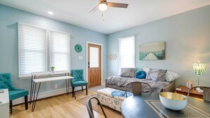 A modern living room with a sofa, a dining table, and a ceiling fan. - Modern Ocean City Getaway: Walk to Boardwalk! (Ocean City)