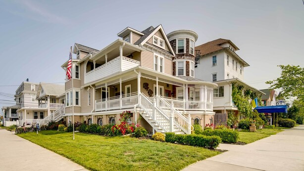 A two-story house with a balcony, a front porch, and a flag. - Modern Ocean City Getaway: Walk to Boardwalk! (Ocean City)