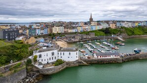 A coastal town with colorful buildings, a church spire, and a marina with boats.