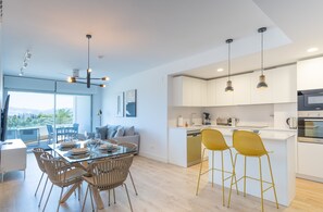 Enjoy meals in the dining area with a glass-top table and comfortable chairs, or grab a seat at the central kitchen island with bar stools.