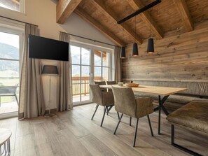Ein moderner Essbereich mit Holztisch, Stühlen und einer Couch.