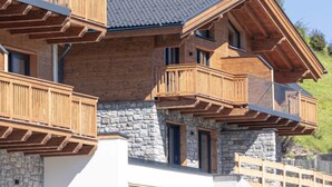 Un immeuble à plusieurs étages, doté de balcons en bois et de murs en pierre.