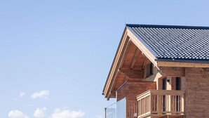 A multi-story building with a wooden facade and balconies. - Superior # 4D mit Sauna by Interhome (Uttendorf)