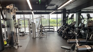 Et fitnesscenter med forskellig træningsudstyr, herunder løbebånd og styrkemaskiner.