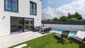 A modern two-story house with a glass door entrance, a swimming pool, and a well-maintained lawn. - Villa Valero by Interhome (Novigrad (Istra))
