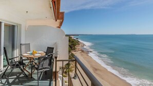 Balcón con mesa y sillas con vista a la playa.