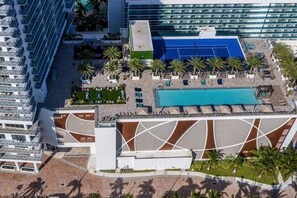 An aerial view of a hotel with a swimming pool, palm trees, and modern architecture. - Condo in Hollywood Beach 3-2 (Hollywood)