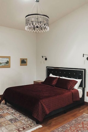 Un dormitorio con cama, candelabro y alfombra.