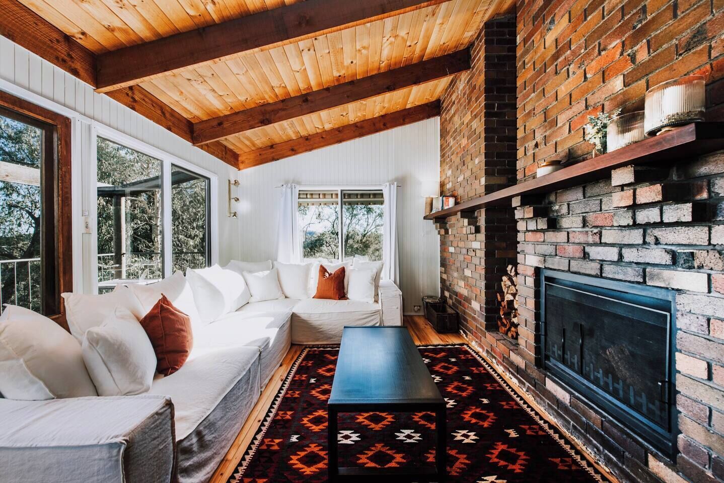 Cosy up by the fireplace in the living room, surrounded by nature's beauty.