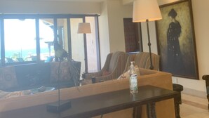 A living room with a sofa, a coffee table, a lamp, and a painting on the wall. - Vacations smutny 
 (Cabo San Lucas)