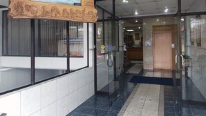 A hotel entrance with a reception desk, a security checkpoint, and a sign indicating a restaurant. - Hotel Esmeralda (Castro)