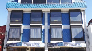 A hotel with a blue and white facade, multiple windows, and a sign reading "Esmeralda". - Hotel Esmeralda (Castro)
