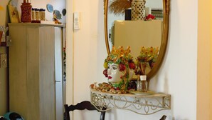 Ein Badezimmer mit Waschtisch, Spiegel und einer dekorativen Vase mit floralem Dekor.