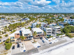 A coastal residential area with modern houses, a swimming pool, and a beach in the foreground. - Fanta-Sea 47 by Beachside Management (Siesta Key)