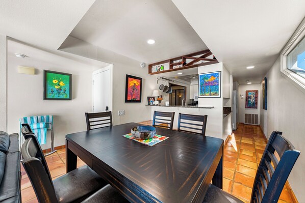 A dining area with a large wooden table, chairs, and a central decorative bowl.