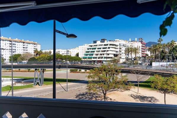 A view of a cityscape with modern buildings, a bridge, and a clear sky.