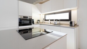 Eine moderne K üche mit schwarzem Arbeitsplatz, Edelstahlgeräten und einem großen Fenster über der Spüle.